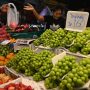 Shoppers browsing fresh vegetables at a farmers market stall