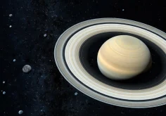 Saturn and its rings surrounded by many small moons in deep space