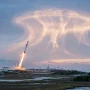 SpaceX rocket launch creating a glowing jellyfish cloud in the dawn sky over the US East Coast